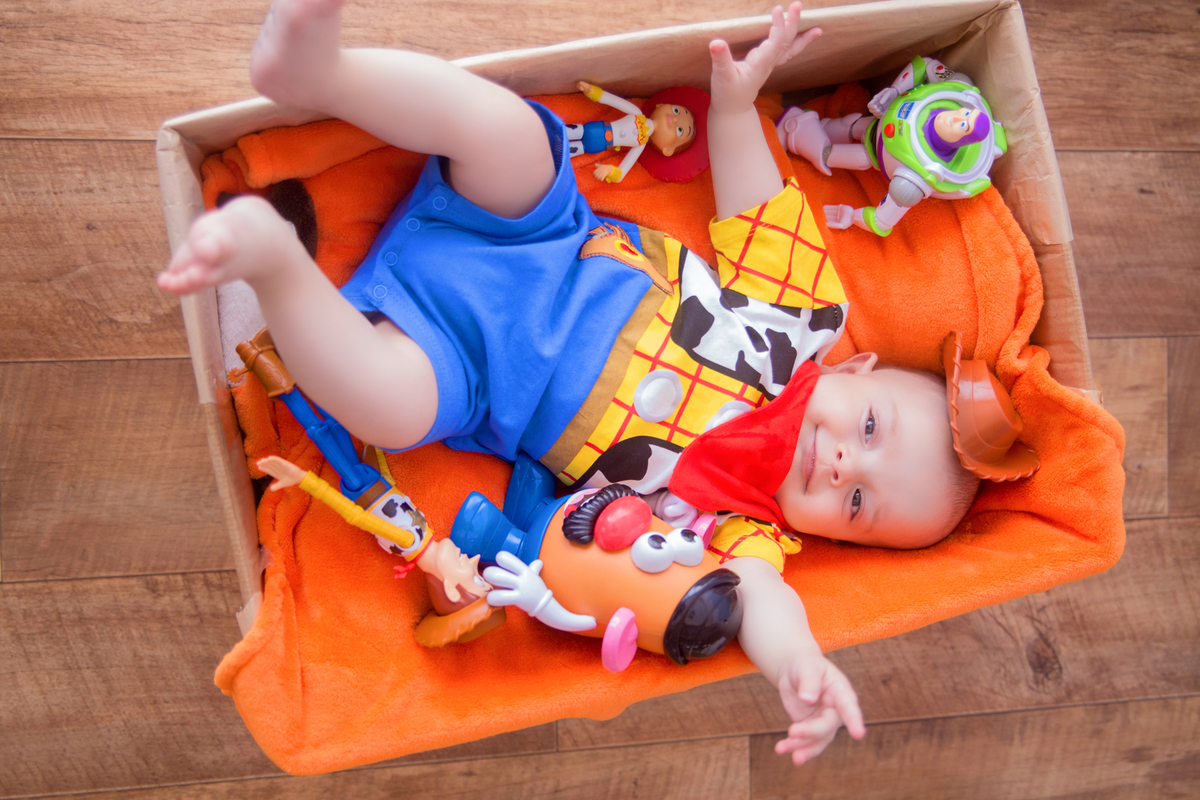 o bebê está deitado na caixa de papelão no cenário de toy story