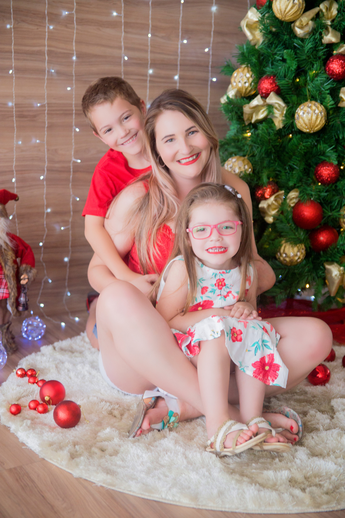 a família sorri para a câmera em sua sessão de natal