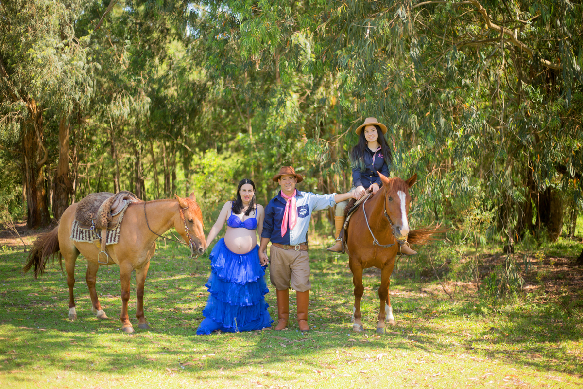 a família posa para a fotógrafa em sessão de gestante