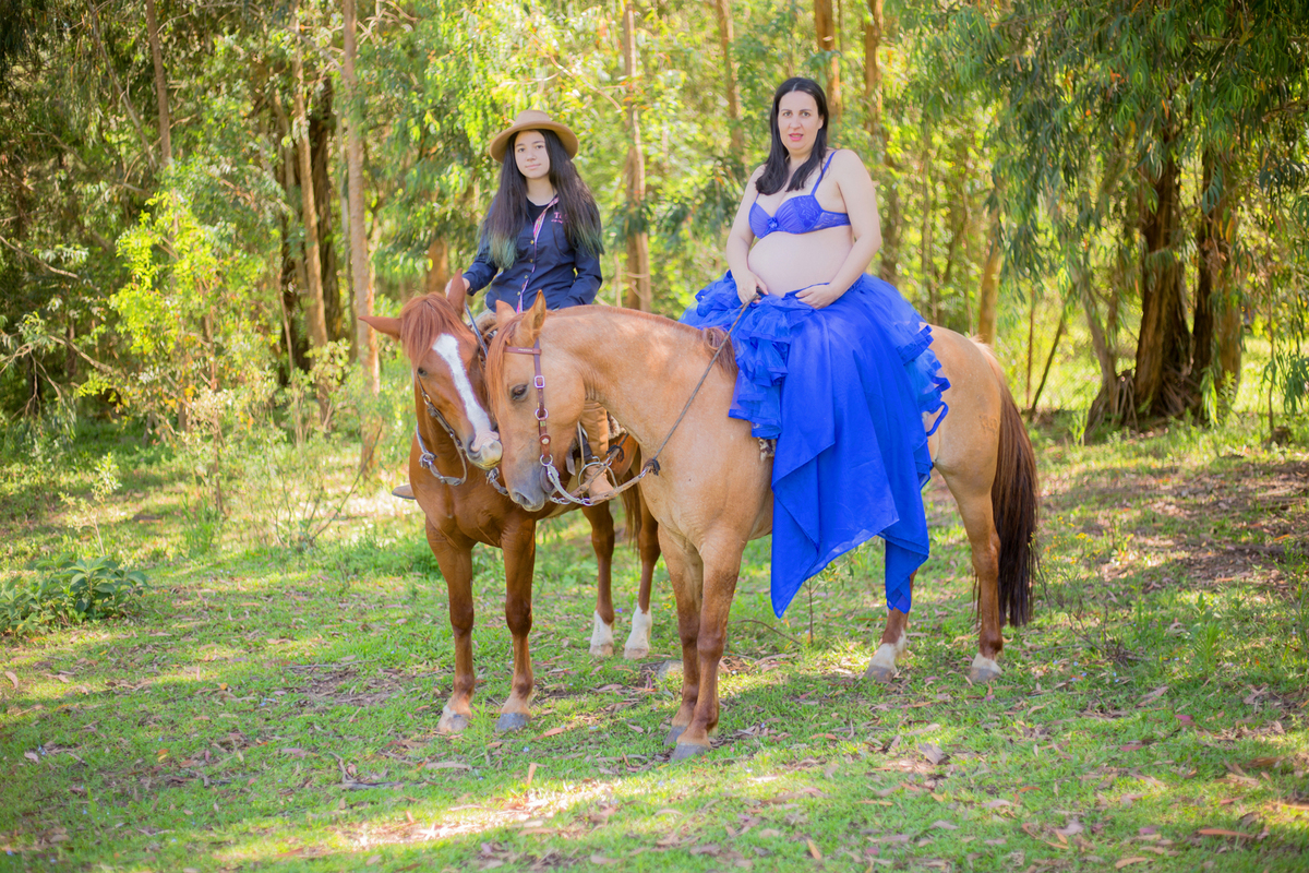 a mãe e a filha posam para a fotógrafa de gestante