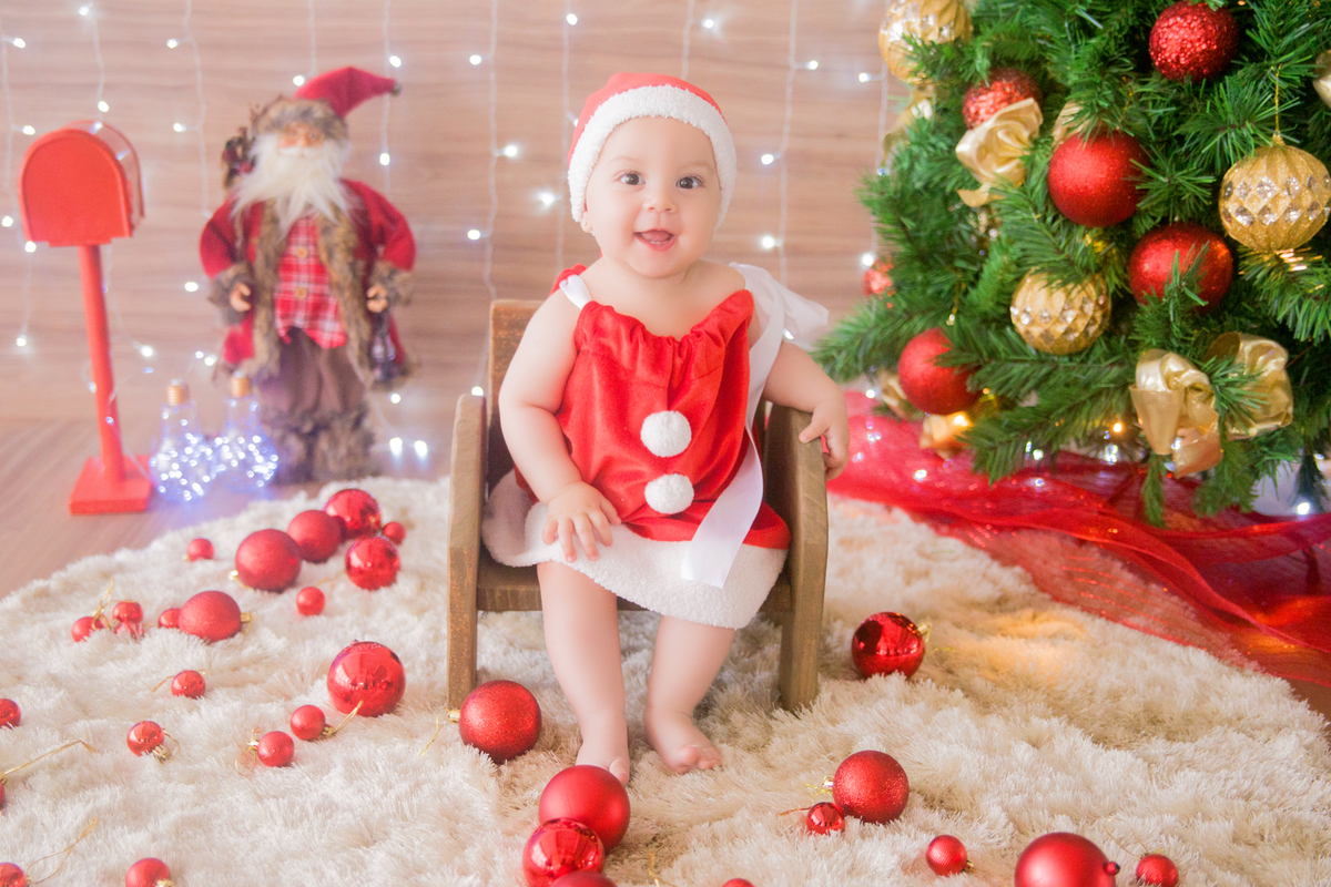 a bebê está sentada no banquinho em sua sessão de fotos de natal
