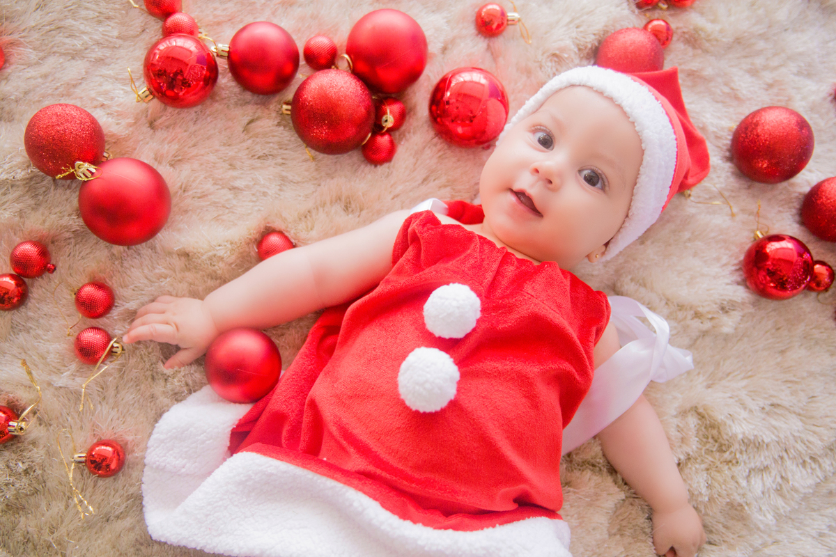 a bebê está deitada no tapete em sua sessão de fotos infantis