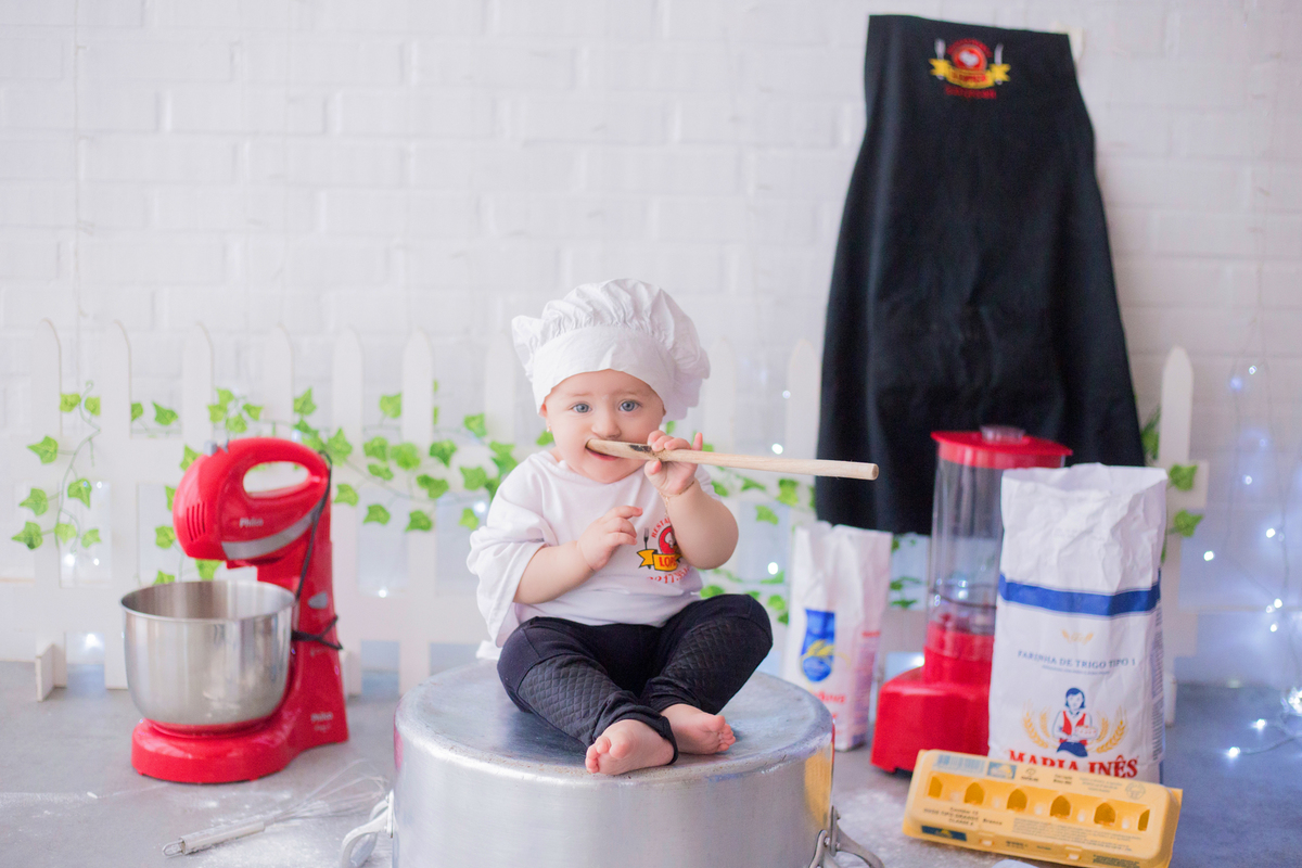 a bebê está sentada em cima da panela em seu acompanhamento mensal
