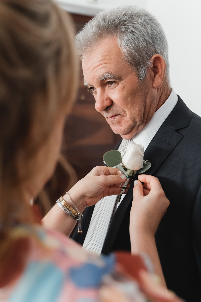 pai da noiva a colocar a flor na lapela