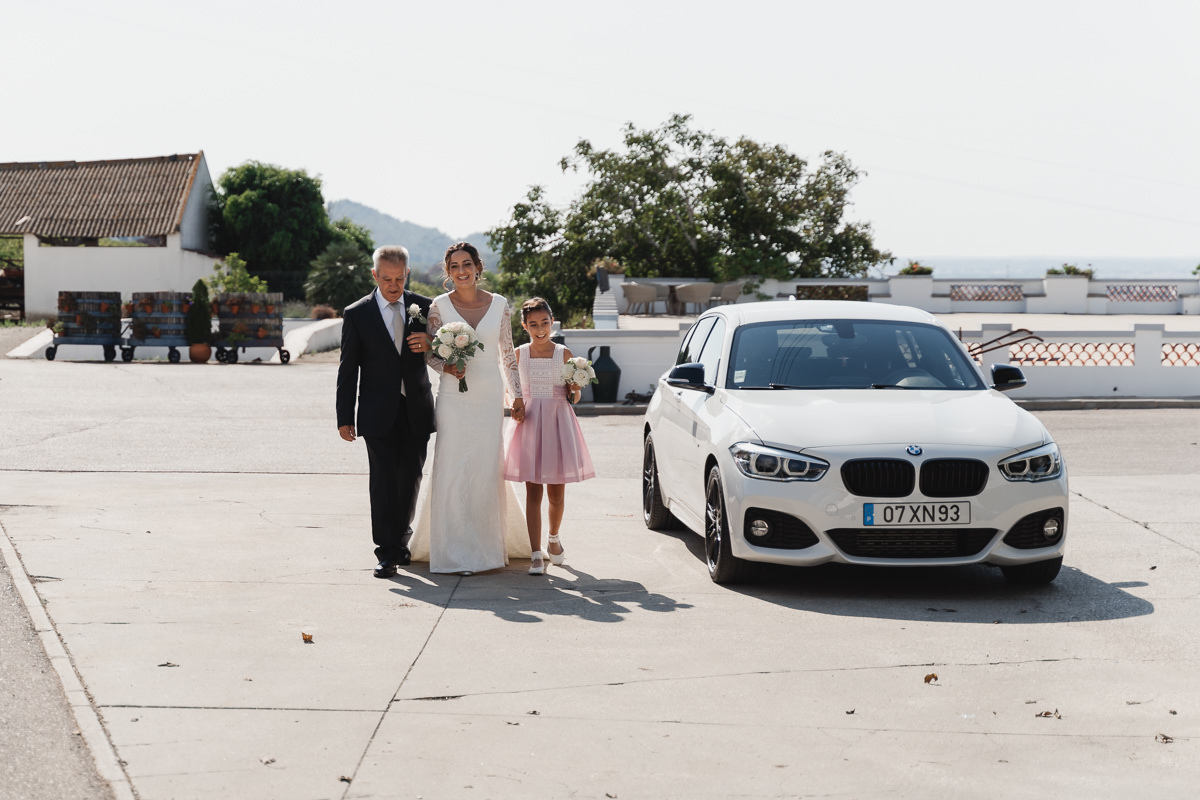 noiva a caminhar acompanhada pelo pai e pela filha