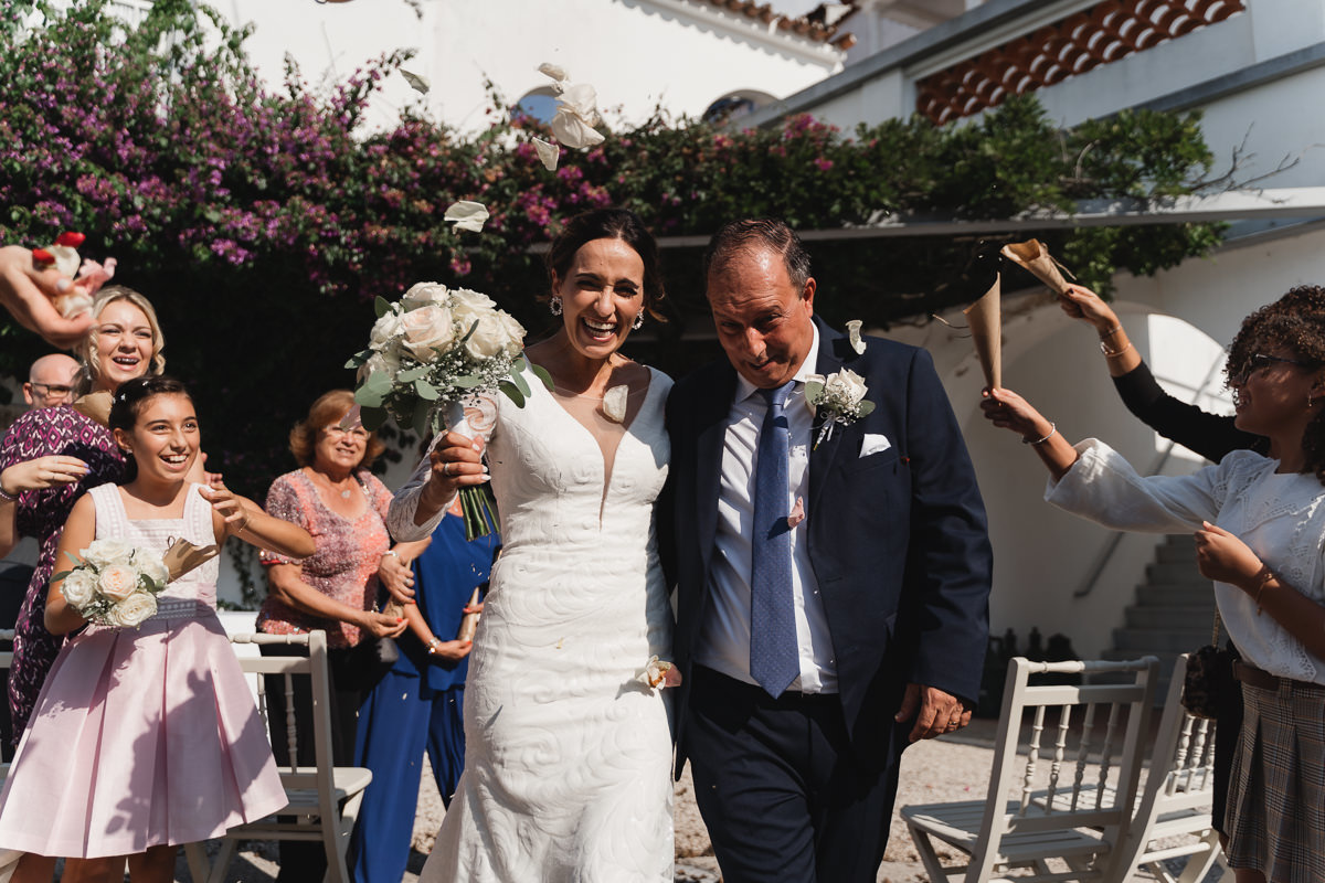 noivos a caminhar pelo corredor enquanto os convidados atiram as pétalas
