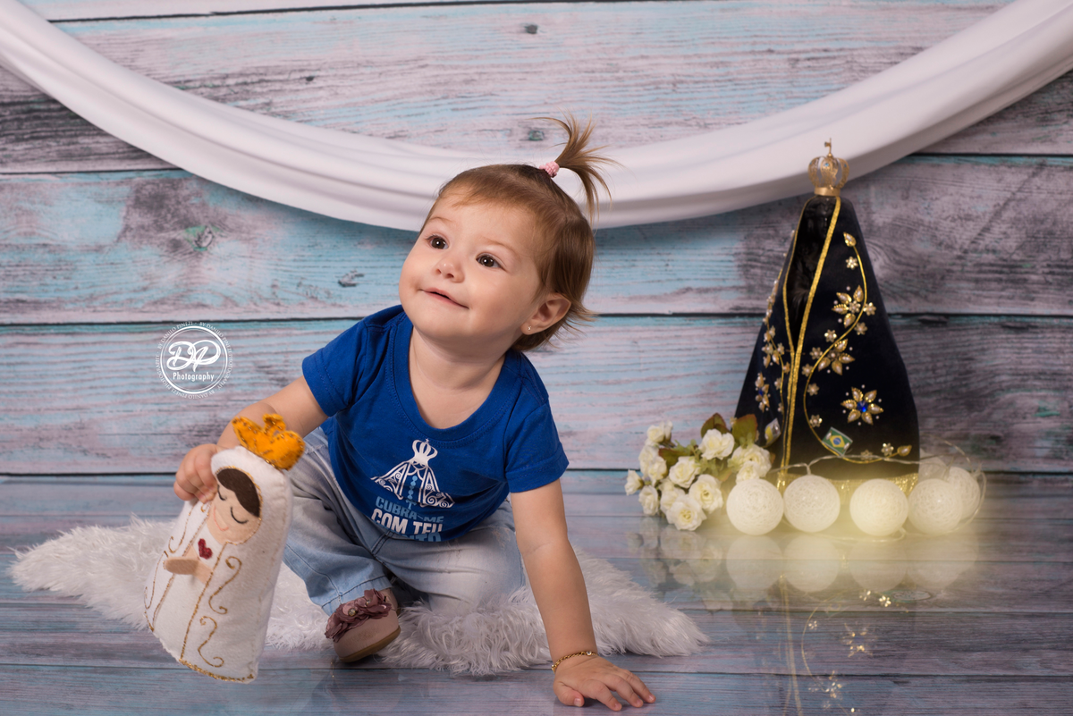 Sessão de um ano de menina, em homenagem à Nossa Senhora Aparecida, com camisetas personalizadas, imagem, luzes e rosa vermelha