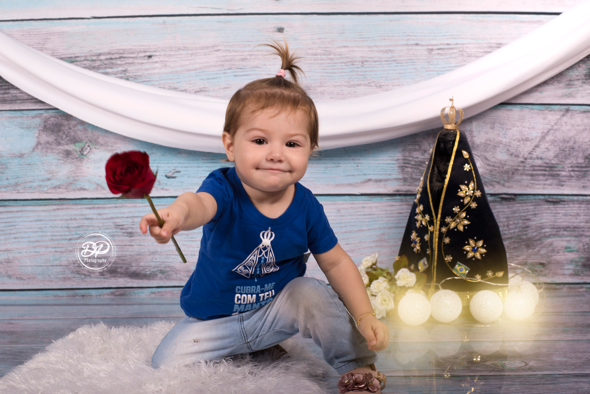 Sessão de um ano de menina, em homenagem à Nossa Senhora Aparecida, com camisetas personalizadas, imagem, luzes e rosa vermelha