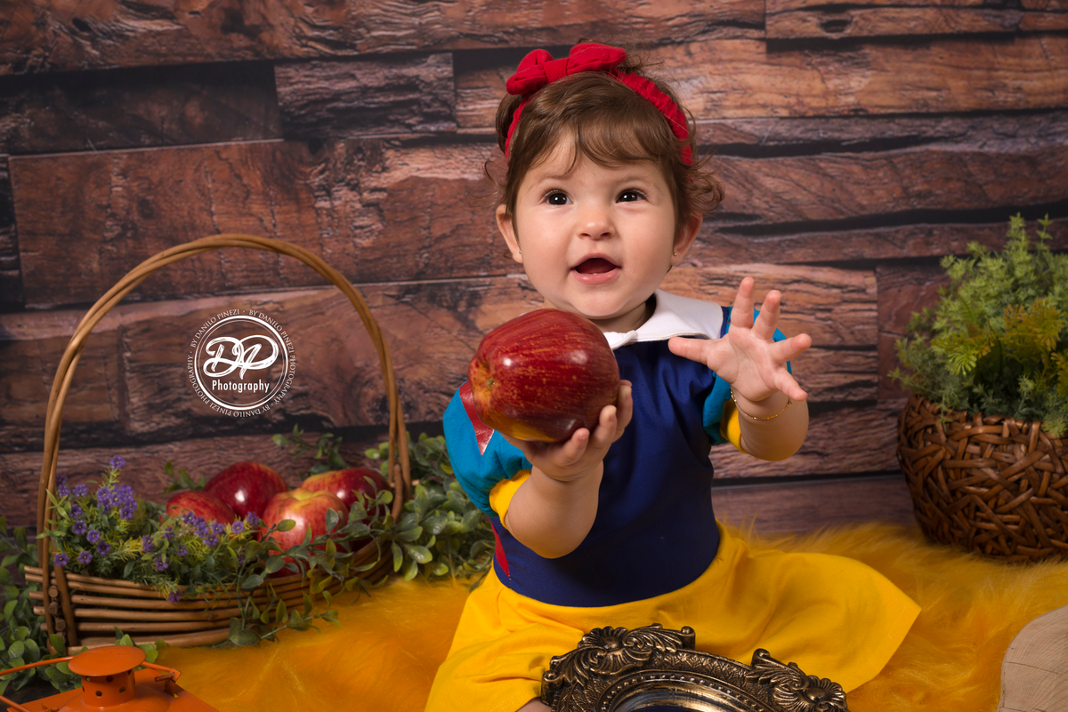Ensaio Branca de neve em estúdio, com maçãs, flores artificiais e espelho, no estúdio Danilo Pinezi Fotografia em Bariri/SP