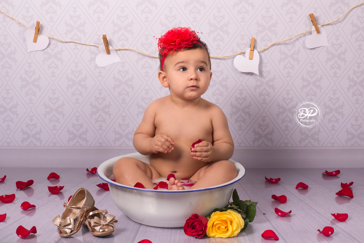 Sessão Milk Bath de menina em estúdio, com pétalas de rosas em fundo vintage.