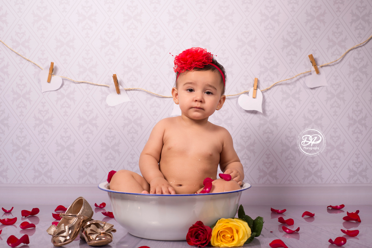 Sessão Milk Bath de menina em estúdio, com pétalas de rosas em fundo vintage.