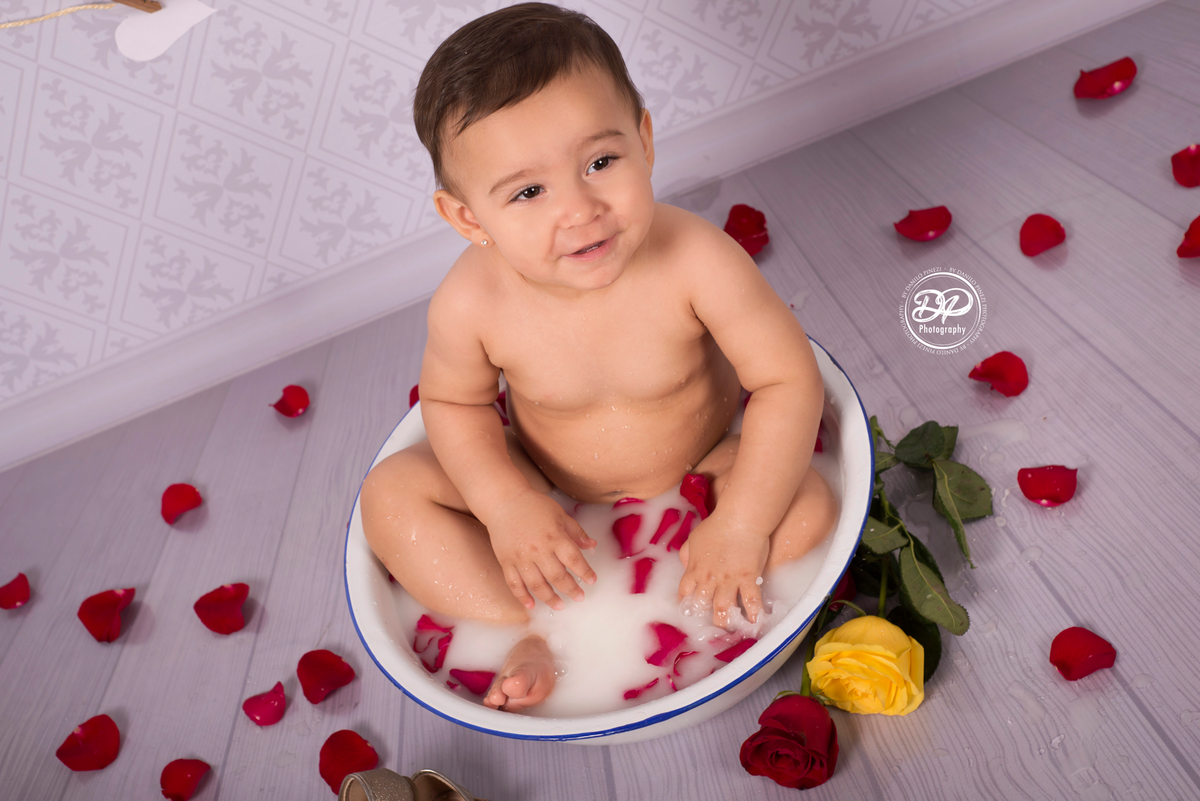 Sessão Milk Bath de menina em estúdio, com pétalas de rosas em fundo vintage.