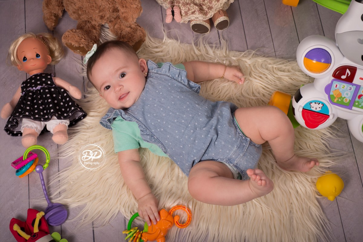 fotografia de bebês, estúdio de bebês, fotógrafo de família, acompanhamento mensal, Danilo Pinezi Fotografia, fotógrafo newborn, quarto de brinquedos, bebê deitada em meio a seus brinquedos