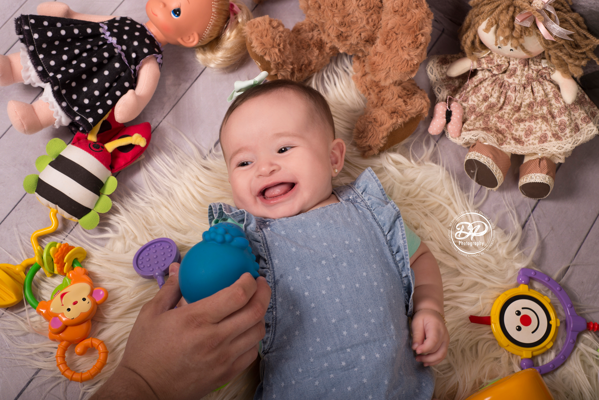 fotografia de bebês, estúdio de bebês, fotógrafo de família, acompanhamento mensal, Danilo Pinezi Fotografia, fotógrafo newborn, quarto de brinquedos, bebê deitada em meio a seus brinquedos