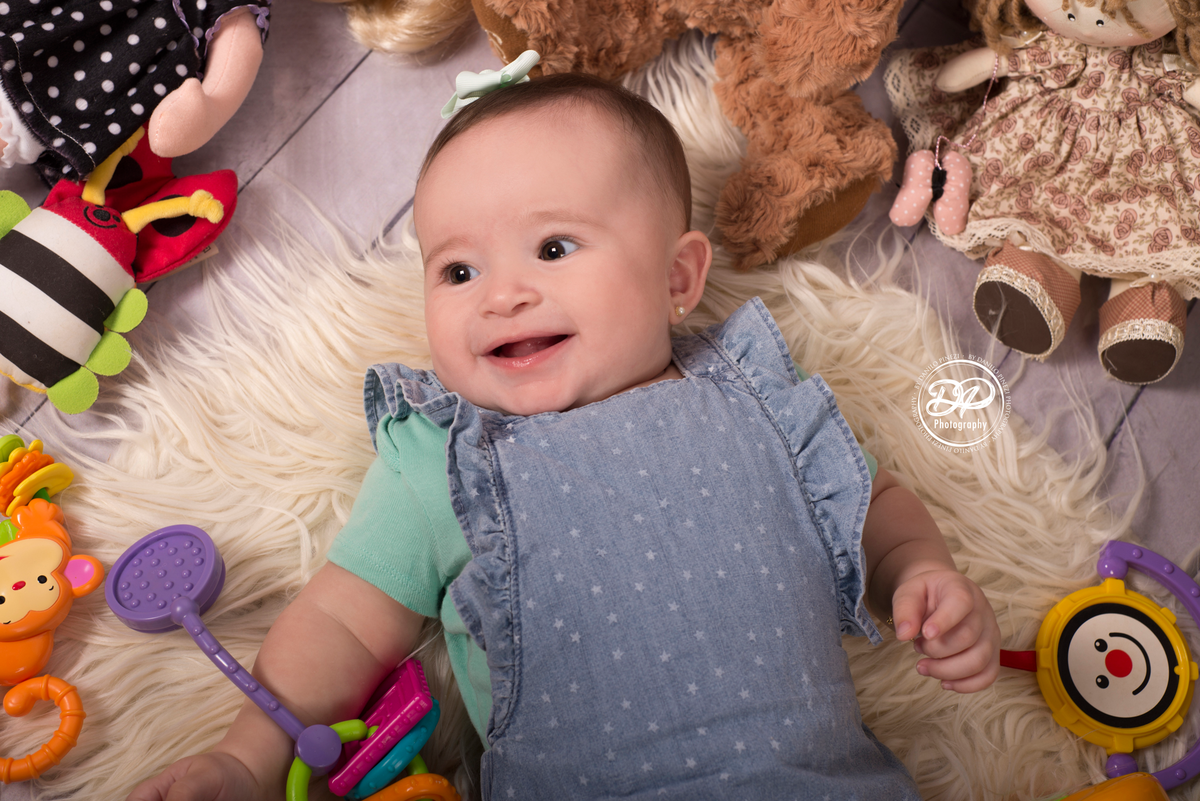 fotografia de bebês, estúdio de bebês, fotógrafo de família, acompanhamento mensal, Danilo Pinezi Fotografia, fotógrafo newborn, quarto de brinquedos, bebê deitada em meio a seus brinquedos