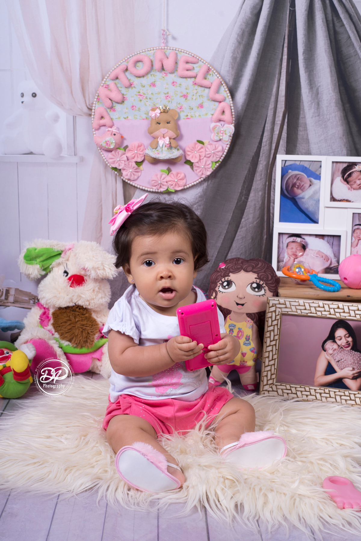 Sessão de bebê menina em estúdio, Tema quarto de Brinquedos, com brinquedos e fotografias espalhados, realizado no estúdio Danilo Pinezi Fotografia