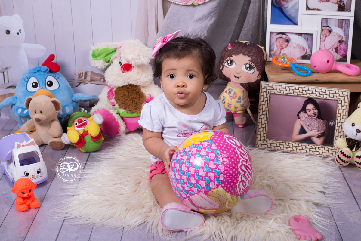 Sessão de bebê menina em estúdio, Tema quarto de Brinquedos, com brinquedos e fotografias espalhados, realizado no estúdio Danilo Pinezi Fotografia