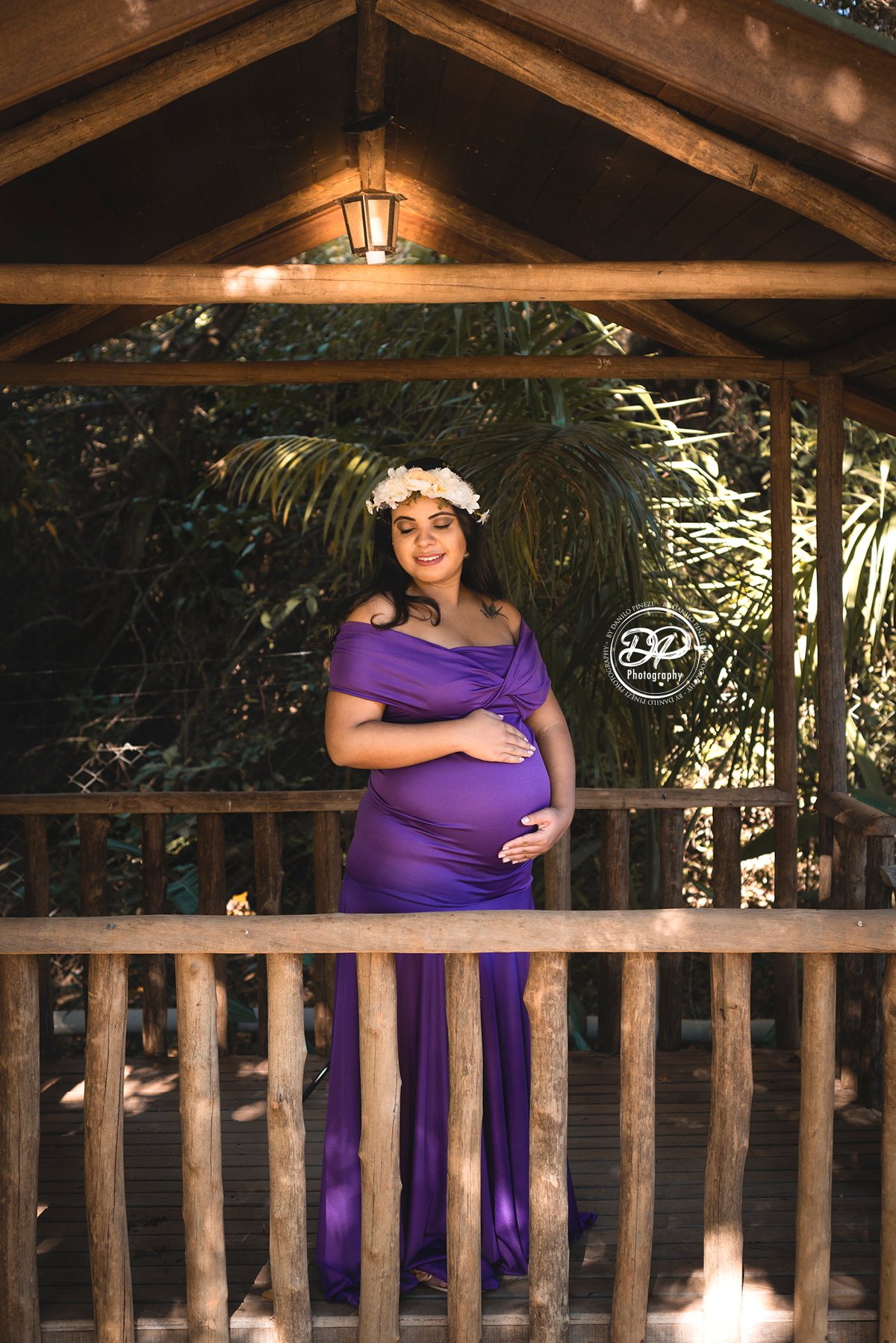 gestante com as mão na barriga, gestante feliz em um jardim