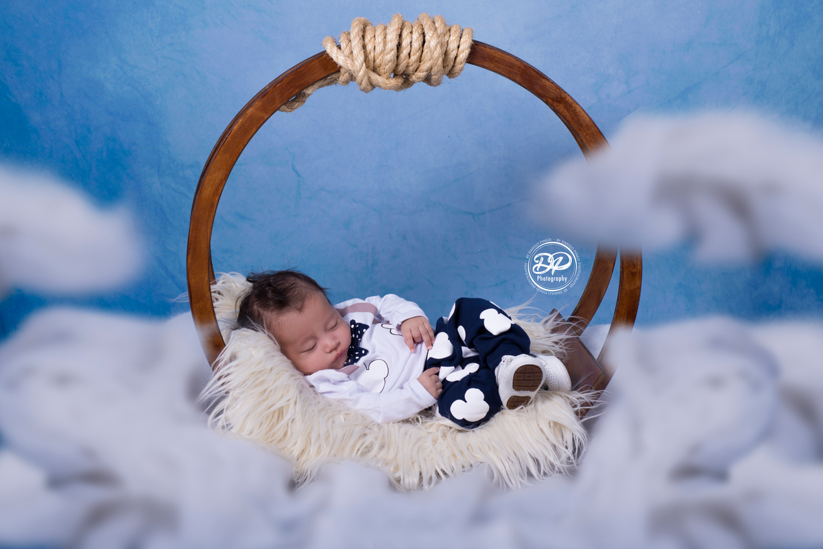Ensaio fotográfico  com balanço circular flutuando nas nuvens, feito para Heitor em seu 2º mês de vida, no Estúdio Danilo Pinezi Fotografia em Bariri