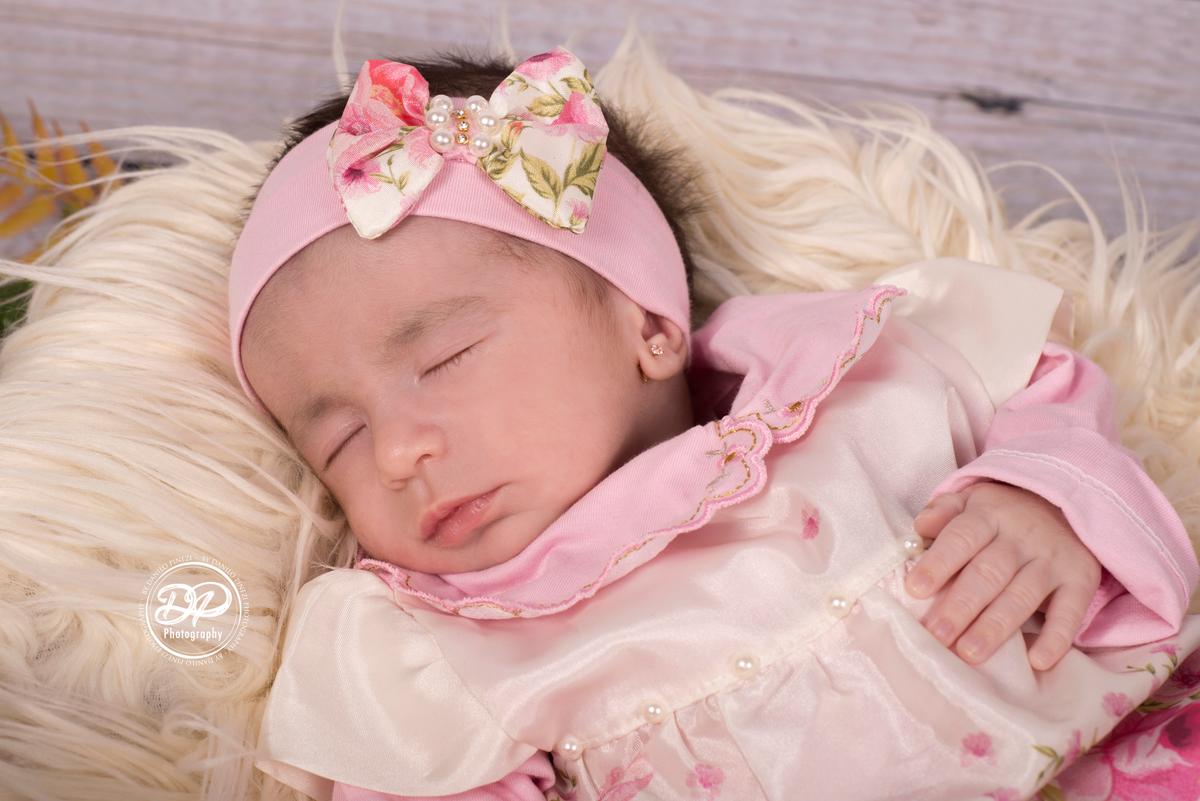 Bebê Isabela deitada dormindo tranquilamente em seu ensaio de 1º mês de vida