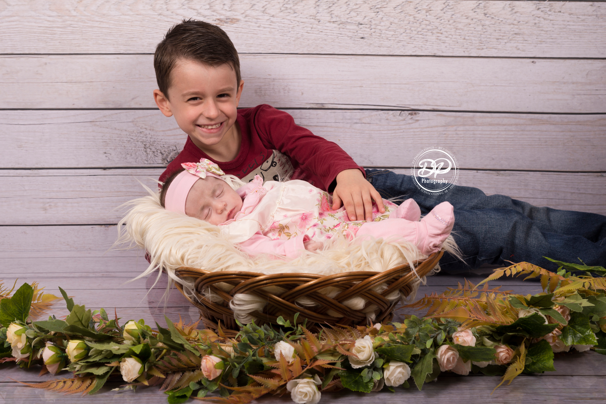 Bebê Isabela deitada dormindo tranquilamente em seu ensaio de 1º mês de vida junto com seu irmão mais velho, no estúdio Fotográfico Danilo Pinezi em Bariri