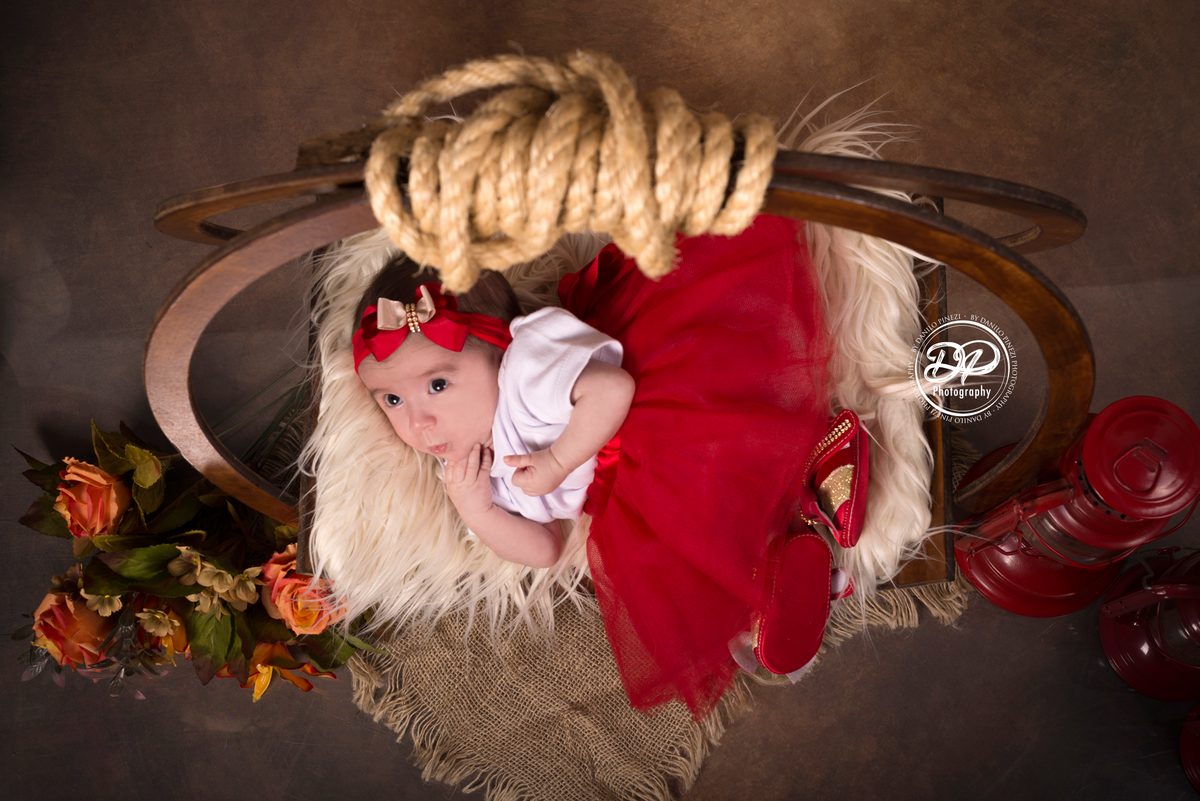 Ensaio balanço circular de 2 meses de Isabela, com flores e vestido vermelho no estúdio Danilo Pinezi Fotografia em Bariri