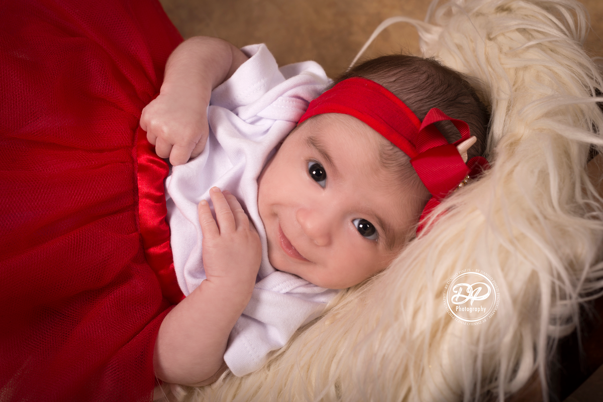 Ensaio balanço circular de 2 meses de Isabela, com flores e vestido vermelho no estúdio Danilo Pinezi Fotografia em Bariri
