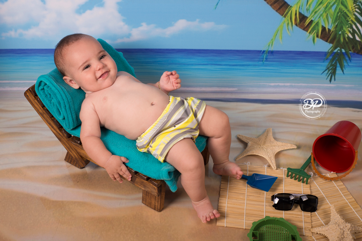 Ensaio menino tema Praia/Verão, com itens e e fundo de praia, feito no estúdio Danilo Pinezi Fotografia em Bariri