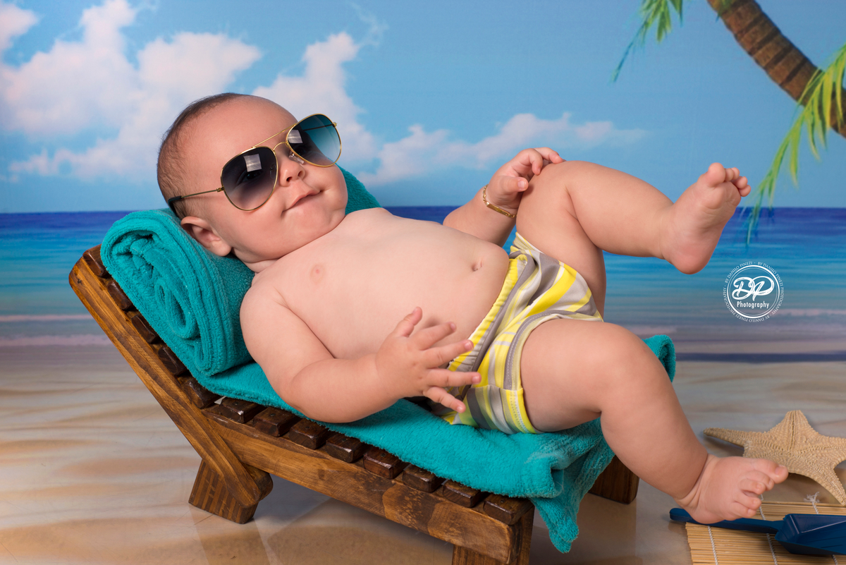 Ensaio menino tema Praia/Verão, com itens e e fundo de praia, feito no estúdio Danilo Pinezi Fotografia em Bariri