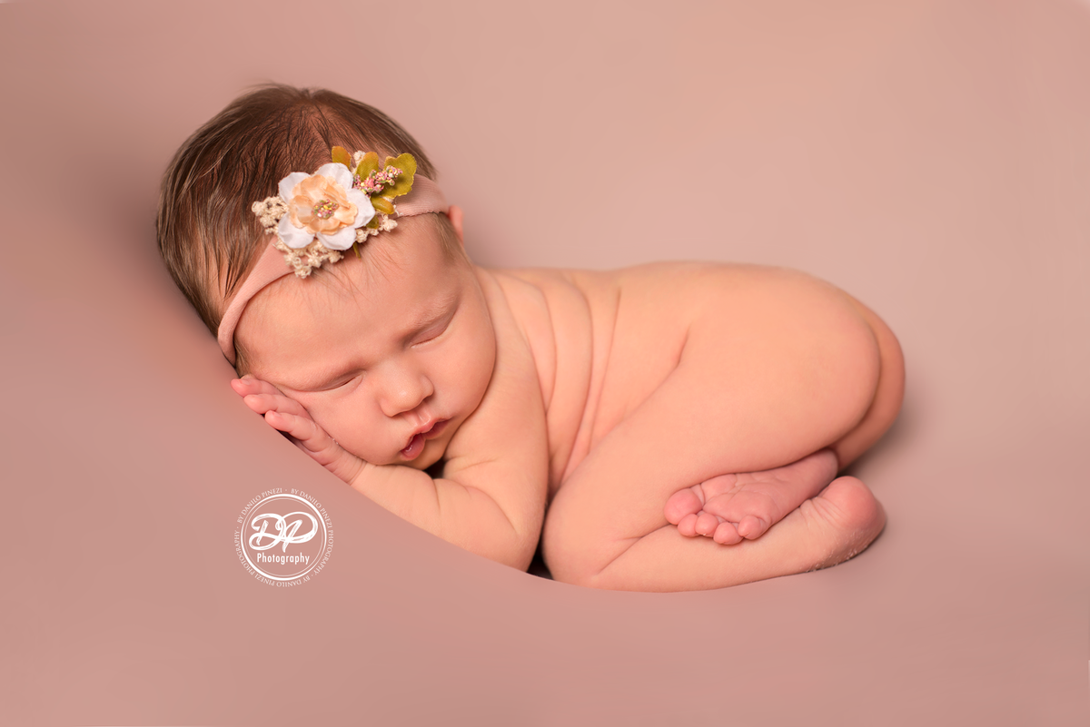 Newborn de menina executado m Bariri, pose do bumbum no puff de fundo rosé, estúdio Danilo Pinezi Fotografia