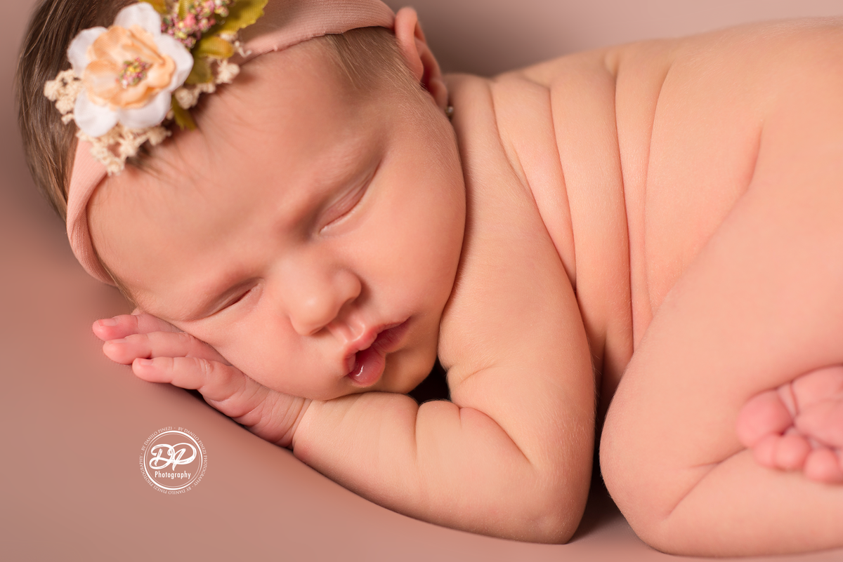Newborn de menina executado em Bariri, pose do bumbum no puff de fundo rosé, estúdio Danilo Pinezi Fotografia