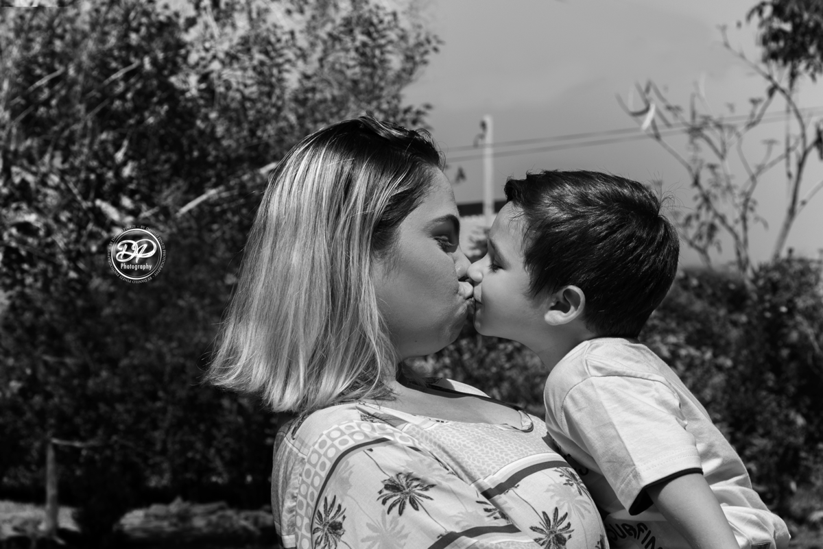 Foto e preto e branco de mãe e filho se beijando em ensaio família  externo feito em bariri/ SP.