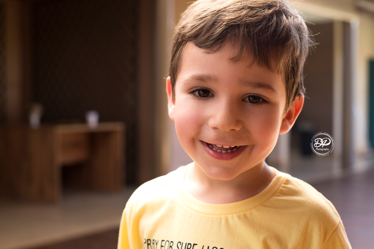 menino sorrindo em ensaio família realizado em Bariri/SP