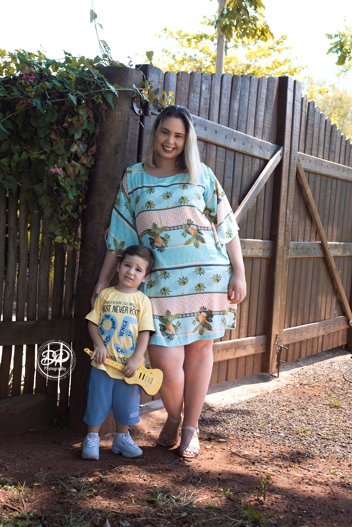 Pés de mãe e filho encostados em um porteira de jardim, em ensaio família feito em Bariri SP