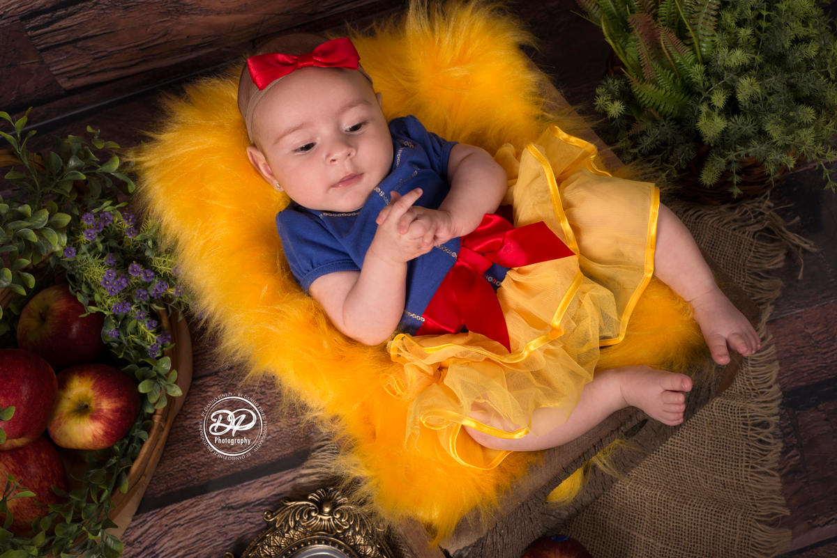 Sessão de 3 meses de bebê menina , tema Branca de Neve, deitada em gaveta rústica, adornado com folhagens e maçãs, em sessão realizada no estúdio Danilo Pinezi Fotografia. Fotos com os pais