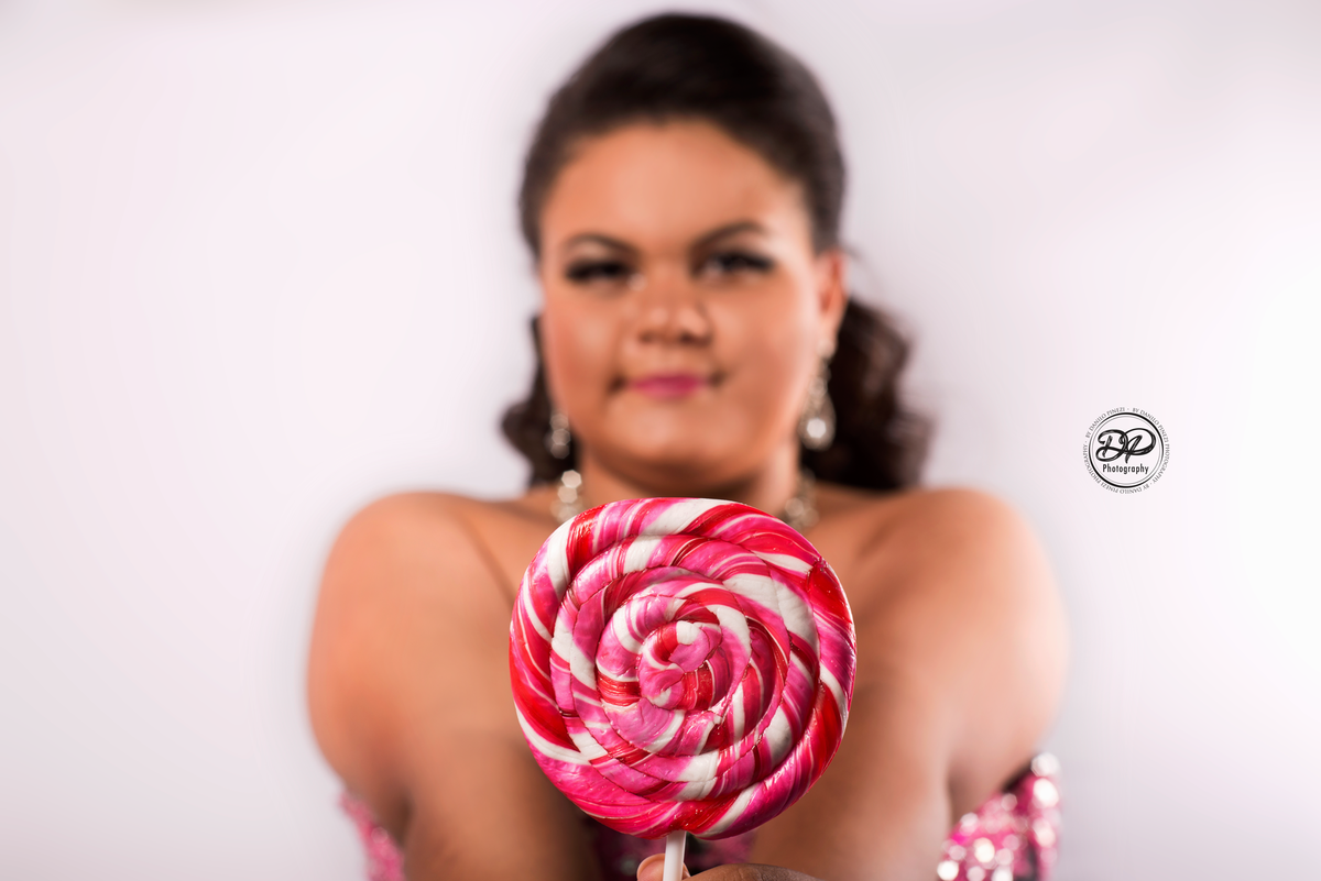 Ensaio 15 anos de menina, pré festa, com vestido de festa, coroa, e pirulito rosa,  feito no estúdio Danilo Pinezi Fotografia em Bariri