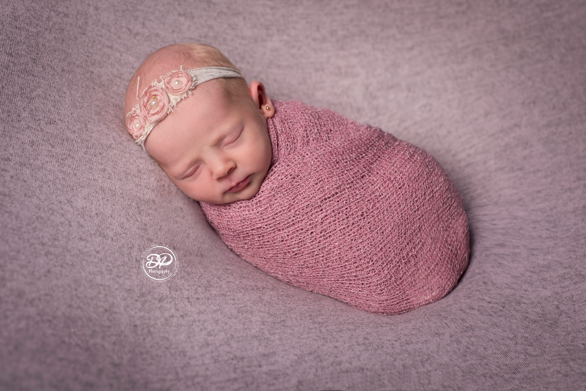 Ensaio newborn de menina, enrolada em wrap