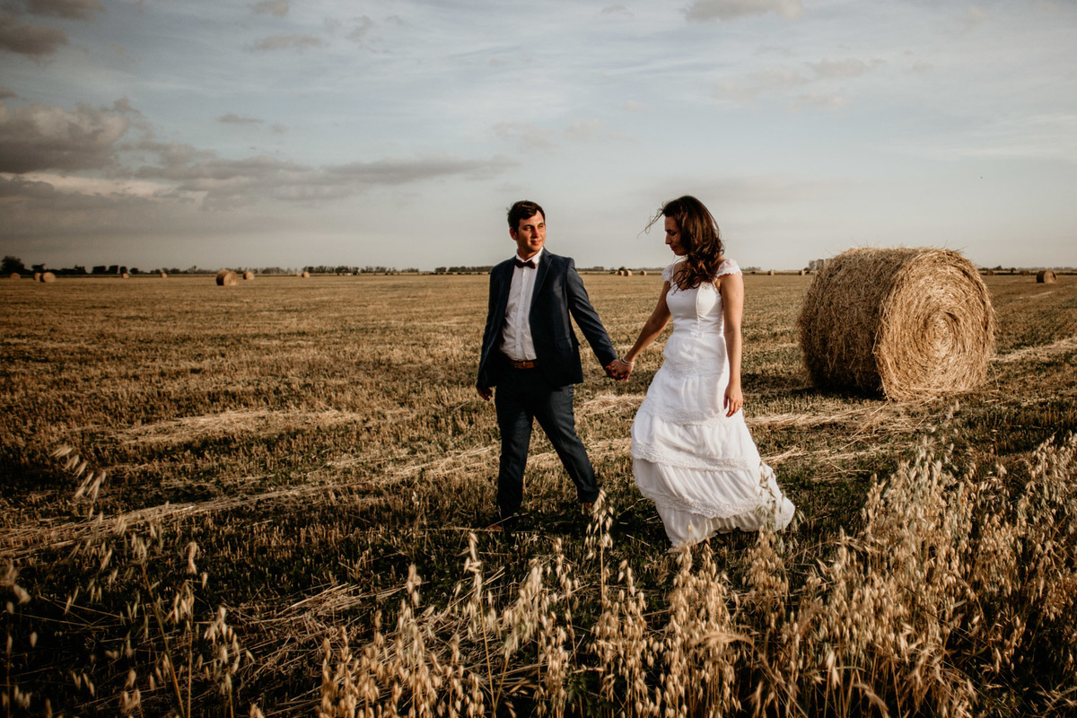 Pareja caminando en el trigo. Atardecer en el campo. Erika Fayolle