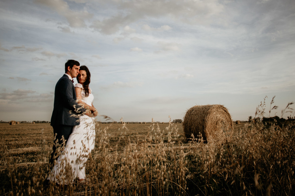 Pareja después de su boda. Atardecer en el trigal. Campo de tarde de verano. Erika Fayolle