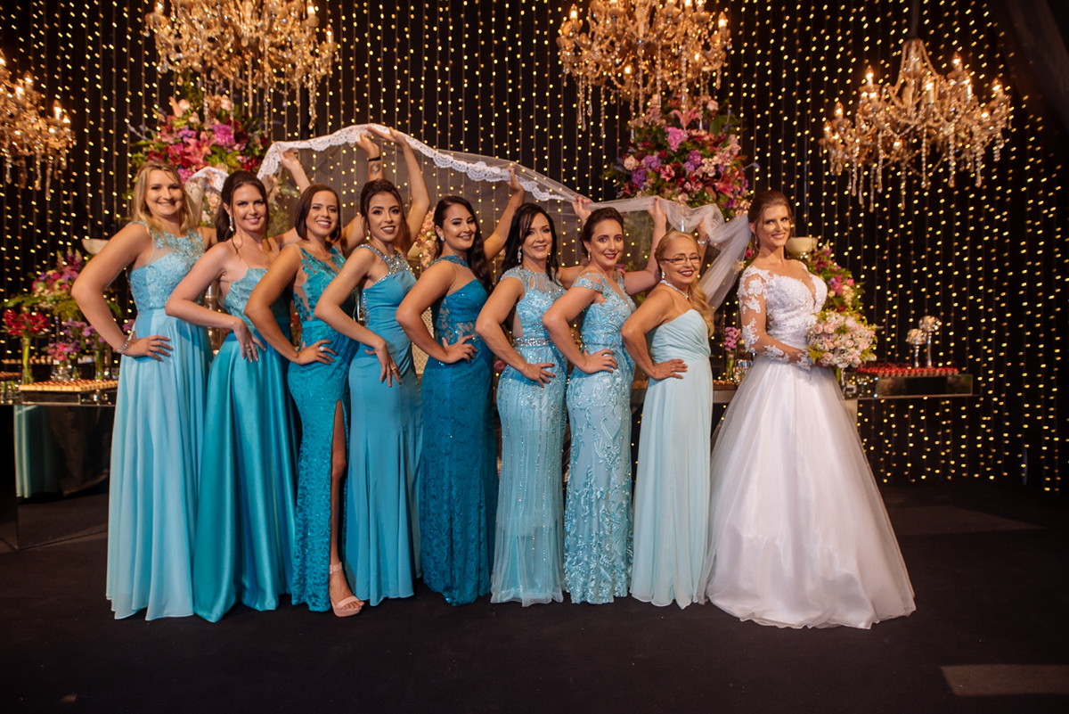 
noivas com madrinhas na mesa do bolo