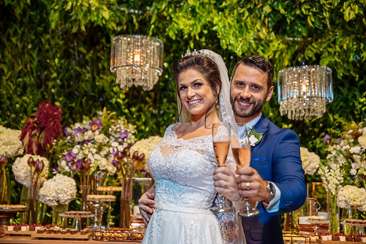noivos brindando na mesa do bolo