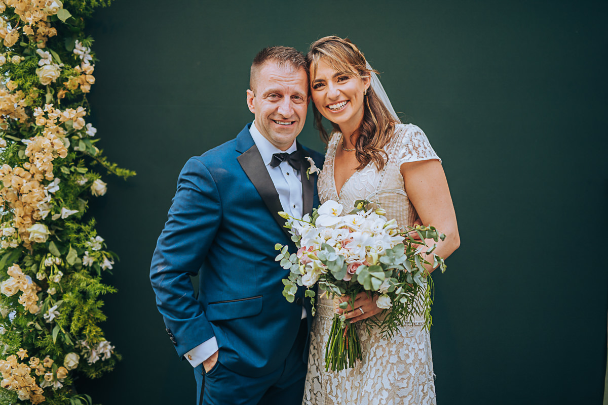 registro fotográfico de um casamento em Vitória-ES, Espírito Santo, noivos em frente a um muro verde