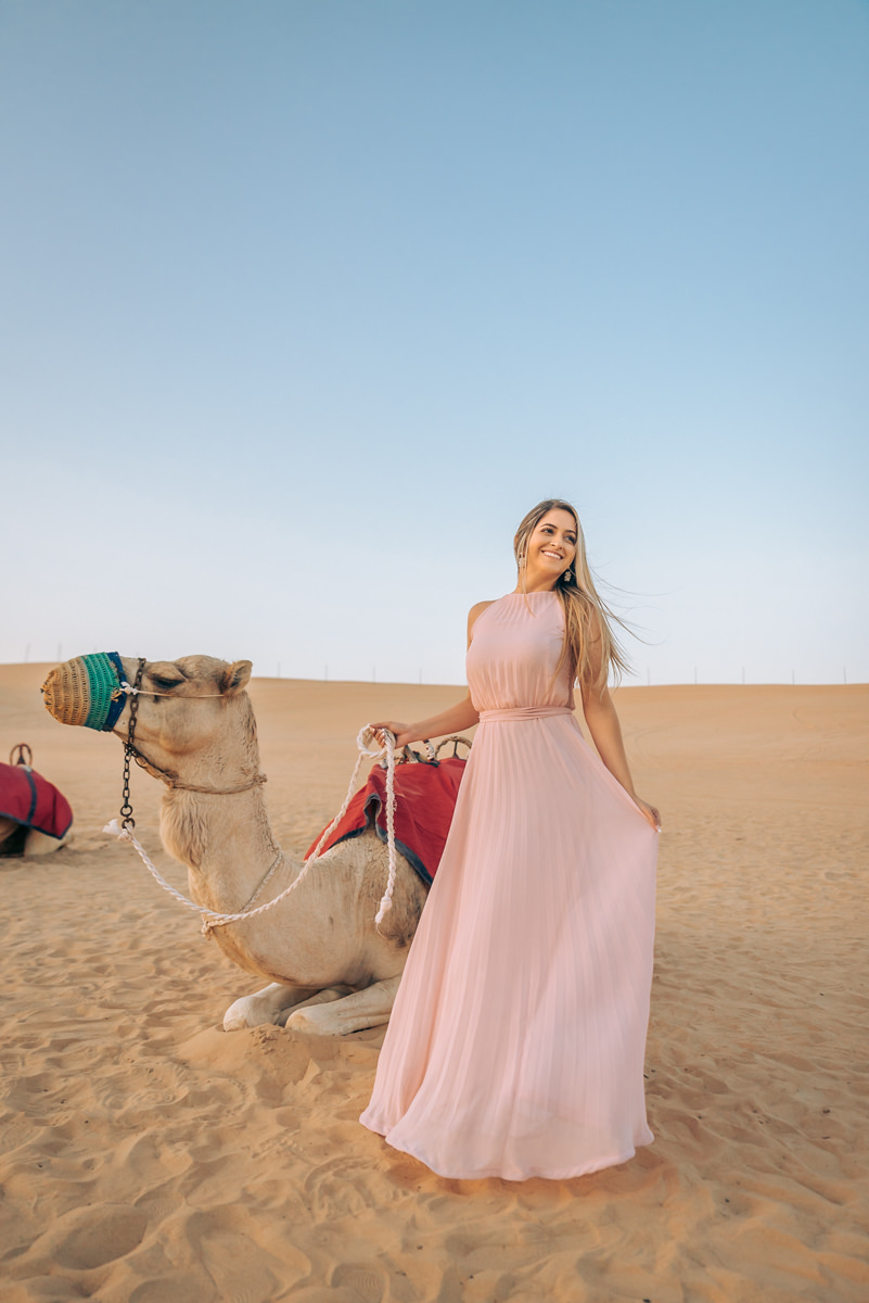 noiva no ensaio fotográfico pré-wedding em Dubai posando em frente a um camelo
