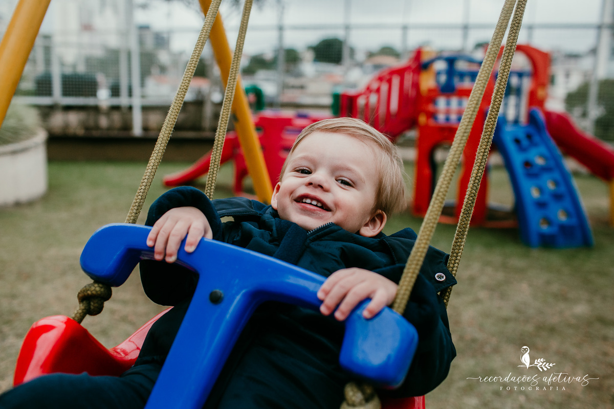 menino sorrindo no balanço