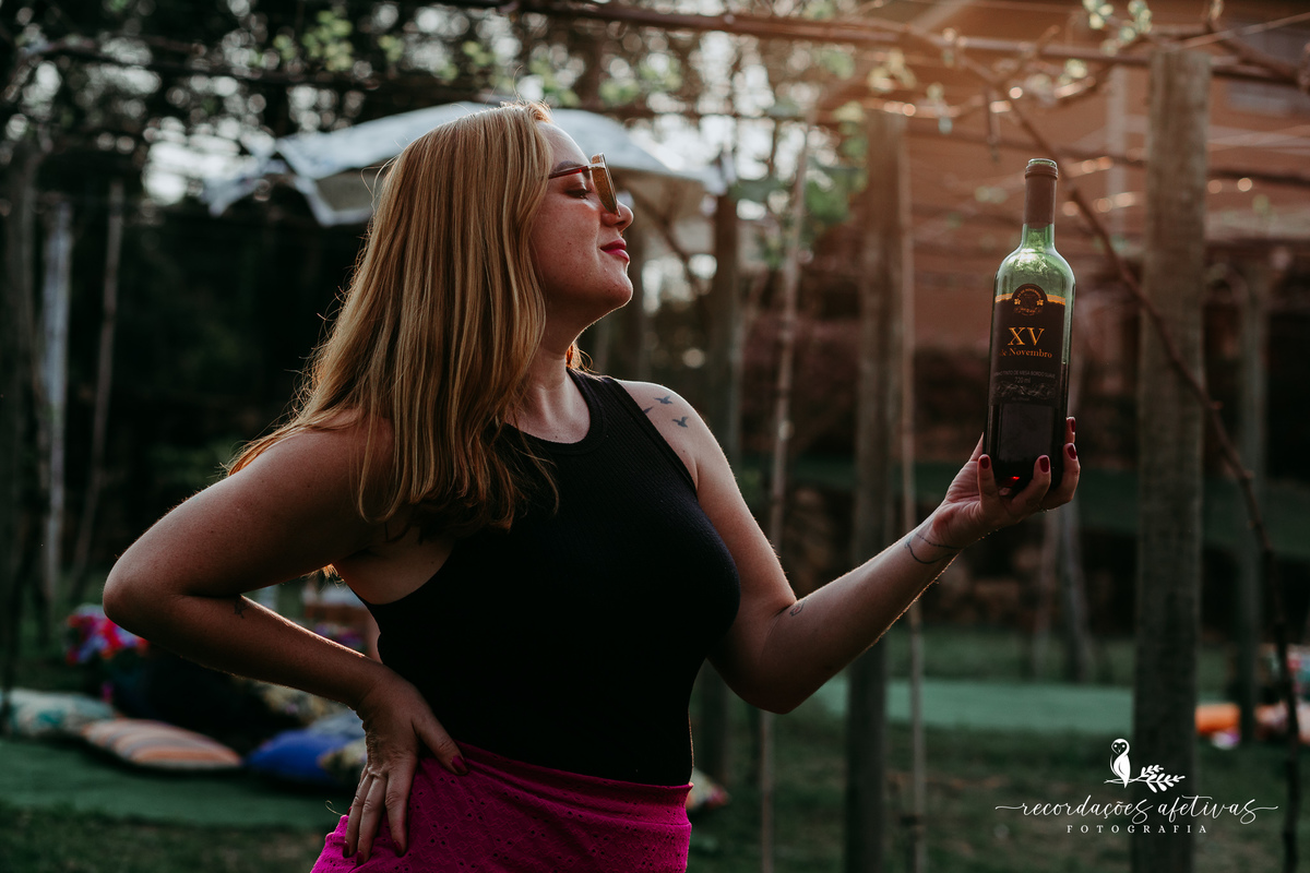 Mulher segurando garrafa de vinho