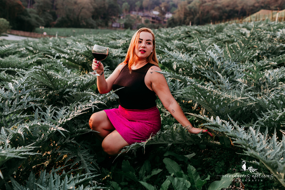 Mulher sentada em plantação de alcachofra