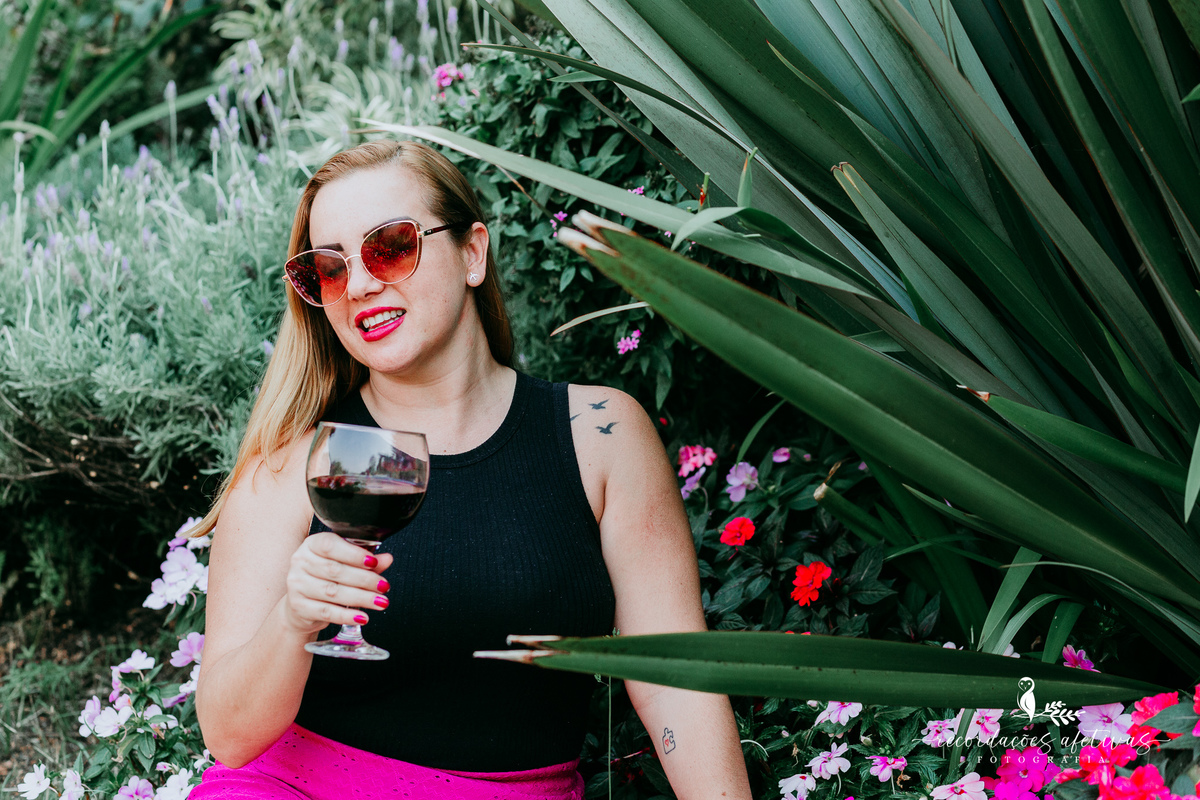 Mulher sorrindo com taça de vinho