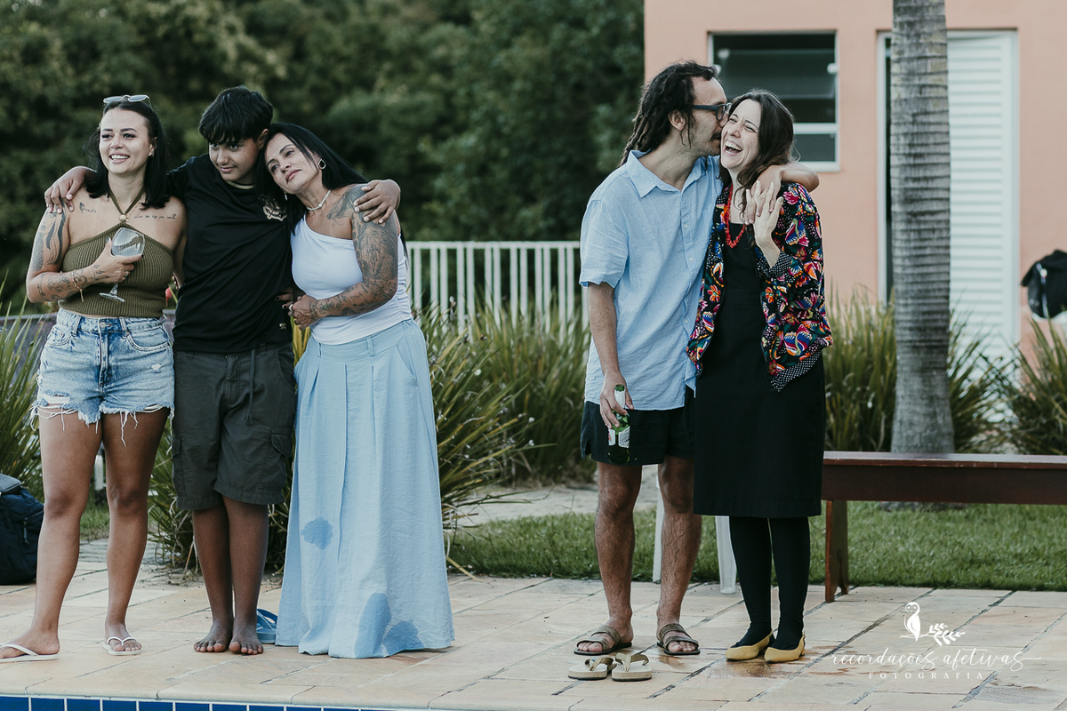 Cena espontânea de afeto entre amigos e familiares durante casamento ao ar livre