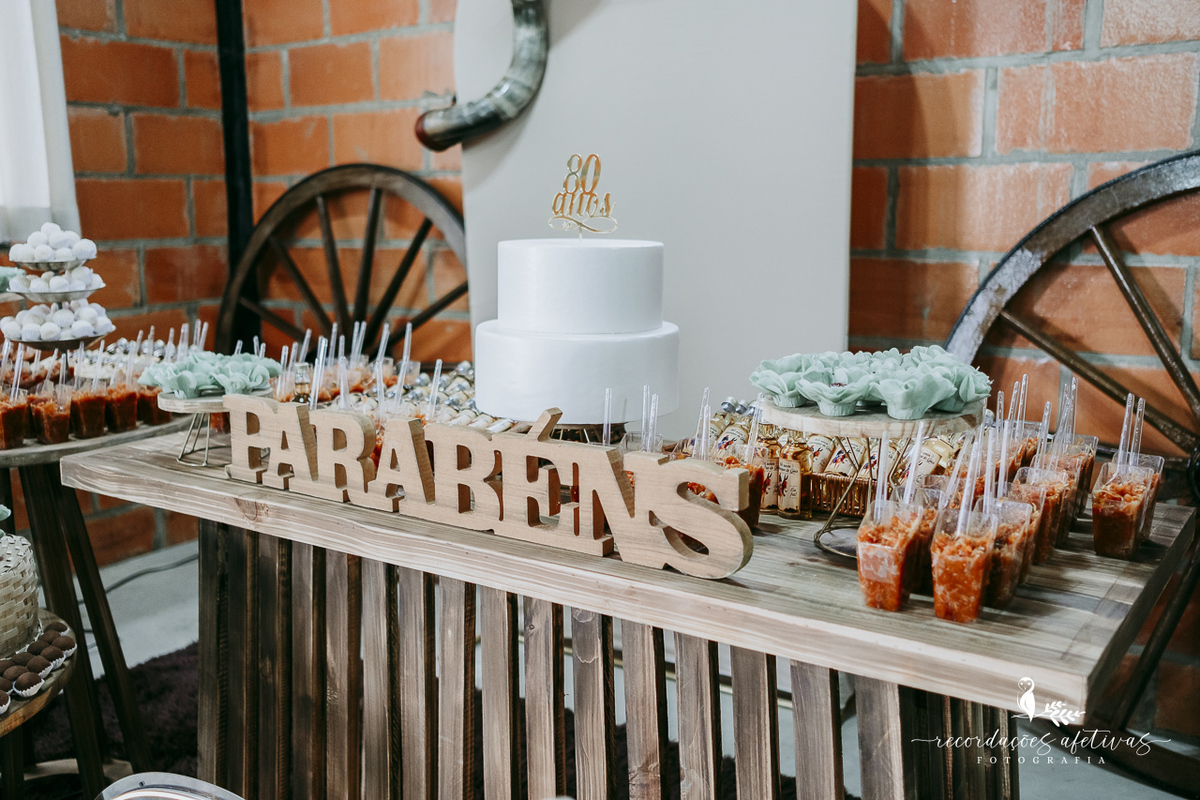 Bolo de 80 anos de Henrique Góes decorado em meio à temática rural e sertaneja da festa.