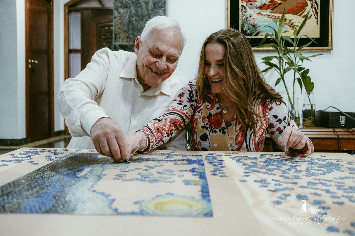 Maria Helena e Omar concentrados na montagem do quebra-cabeça que faz parte da rotina dos dois.